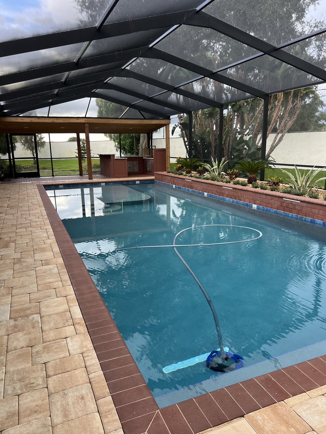 Winter Haven pool and outdoor kitchen: Finished pool with pavers and screened enclosure