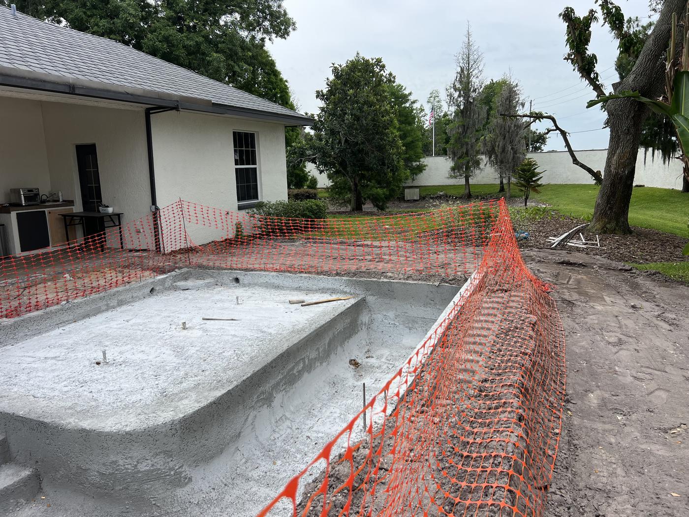 Winter Haven pool and outdoor kitchen: Concrete pool shell with sun shelf and steps